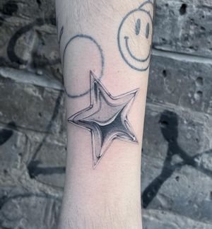 Grace your forearm with a mesmerizing black and gray star tattoo by Fresh Flower. Embrace the night sky's beauty.