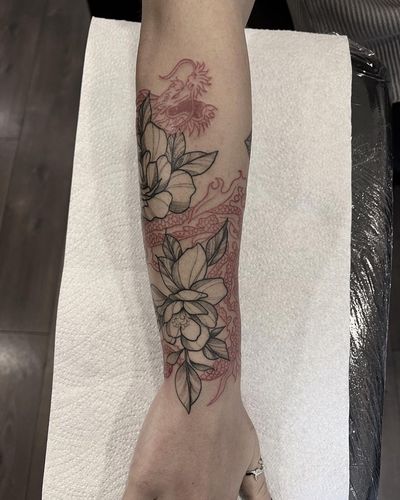 Get a stunning floral tattoo featuring a dragon and peony motif, expertly done by Federico Colantoni on your arm.