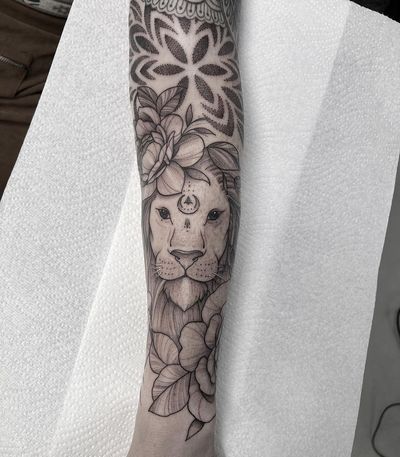 Elegant dotwork and fine line tattoo by Federico Colantoni, beautifully combining the fierce lion motif with intricate mandala details on the arm.
