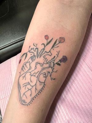 Ignorant style forearm tattoo featuring a delicate flower and heart motif by Kiky Flore.