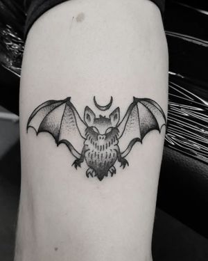 Elegant black and gray fine line tattoo of a crescent moon and bat by Elisa Thirteen.