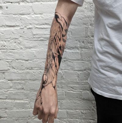 A stunning black and gray tattoo by artist George Antony featuring a detailed fish, pattern, and eye design on the forearm.
