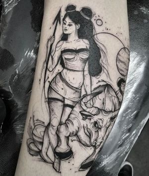 Get mesmerized by Elisa Thirteen’s stunning black and gray tattoo featuring a majestic bull and an elegant lady on your lower leg.