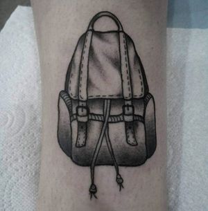 Explore the unknown with this intricate black and gray backpack tattoo on your forearm by Elisa Thirteen.