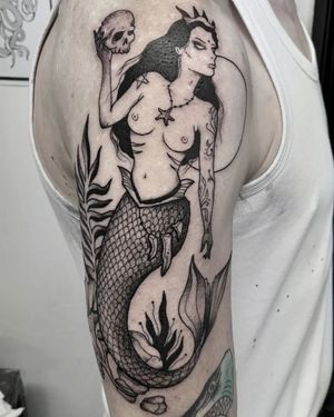 Captivating black and gray tattoo featuring a skull and mermaid, expertly done by Elisa Thirteen on the upper arm.