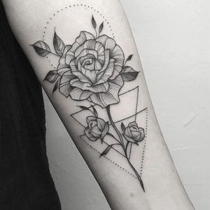 Elegant black and gray fine line design by Elisa Thirteen featuring a stunning geometric rose pattern. Perfect for your forearm!