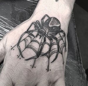 Get a creepy yet elegant black and gray spider tattoo on your hand by the talented artist Elisa Thirteen.