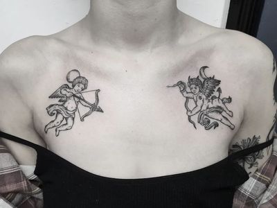 Elegant black and gray angel and cupid tattoo on chest by Elisa Thirteen, symbolizing pure love and divine protection.