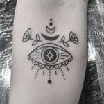 Exquisite forearm tattoo featuring delicate flower and eye motifs by Elisa Thirteen. Perfect blend of nature and mystique.