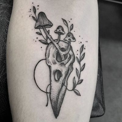 This stunning black and gray tattoo combines a skull and mushroom motif, expertly executed in dotwork style by the talented artist Elisa Thirteen.