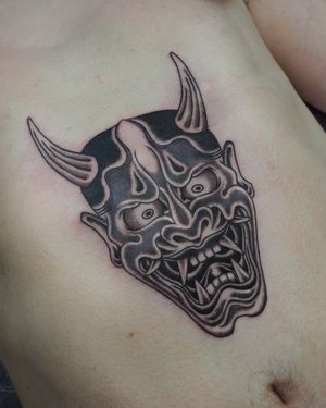 Experience the captivating allure of a traditional Japanese hannya mask tattooed by the skilled hand of Alex Travers on your stomach.