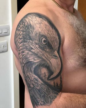 Capture the fierce beauty of an eagle with this striking black and gray tattoo on your upper arm. By talented artist Soheyl Astangi.