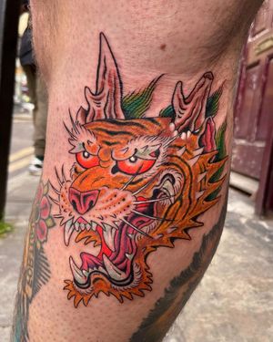 Get a stunning Japanese tiger tattoo on your lower leg by talented artist Alex Travers. Show off your wild side with this fierce design.