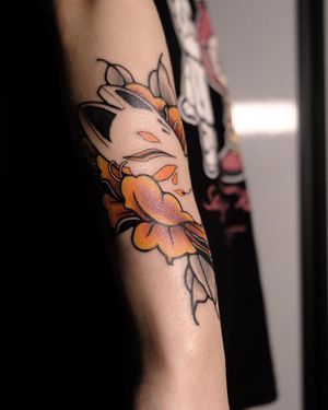 Beautiful forearm tattoo combining a kitsune spirit with a vibrant flower, expertly inked by Jacky Yang.
