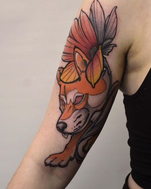 Get a stunning new school style tattoo of a colorful fox and flower design on your upper arm by the talented artist Jacky Yang.