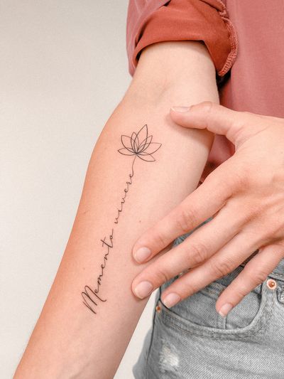 Fine line forearm tattoo by Federico Tronconi featuring a small flower motif and elegant lettering.