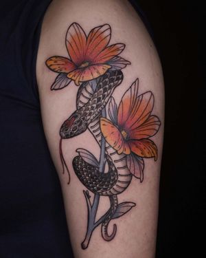 Embrace the beauty of nature with this stunning neo-traditional tattoo by artist Jacky Yang. Featuring a graceful snake entwined with a vibrant flower, this piece is sure to make a statement.