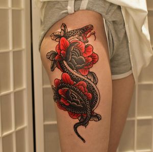 Adorn your upper leg with this stunning neo traditional tattoo featuring a snake intertwined with a flower, expertly crafted by Jacky Yang.