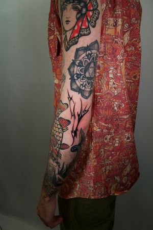 Embrace the ancient art of tribal tattoos with this striking blackwork design on your arm by the talented Jacky Yang.