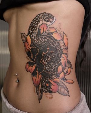 Vibrant colors and intricate details by Jacky Yang for a stunning and symbolic tattoo on your ribs.