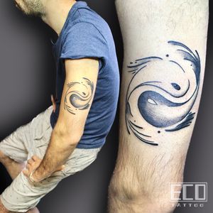 Discover harmony and balance with this elegant black and gray tattoo by Lin Feng, featuring a sleek fish motif intertwined with yin & yang sign on the upper arm.