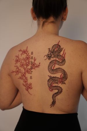 Experience the ancient artistry of a Japanese dragon intertwining with a delicate flower on your back, expertly inked by Federico Tronconi.