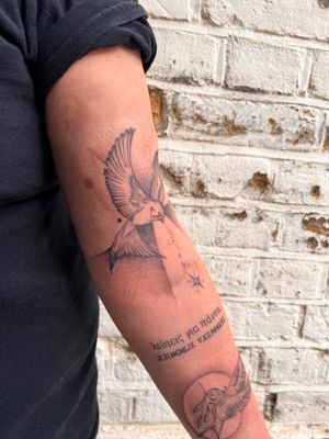 Elegant bird design on upper arm, created with delicate fine line technique by talented artist Kiky Flore.