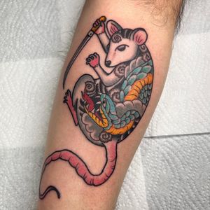 A stunning tattoo by Claudia Trash on the upper arm featuring a neo-traditional style with a snake and rat motif.