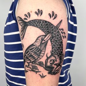 Beautiful black and gray tattoo of bird and fish by Claudia Trash, perfectly placed on the upper arm.