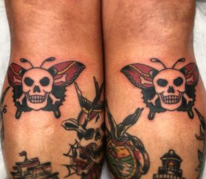 Bold traditional design on lower leg by Claudia Trash, featuring a fierce pirate and delicate butterfly motif.