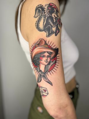 Embrace your inner cowgirl with this traditional style tattoo by Claudia Trash. The strong and confident woman motif will make a bold statement on your upper arm.