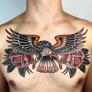 Get inked by Claudia Trash with this bold traditional tattoo featuring a majestic eagle and vibrant flower motif on your chest.