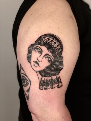 Claudia Trash's skilled hand brings this beautiful woman motif to life on your upper arm. A timeless and classic design that showcases fine line art and traditional tattoo style.
