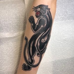 Get inked by Claudia Trash with a bold traditional blackwork panther design on your forearm.