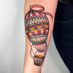 Get a timeless tattoo with a traditional style balloon design on your forearm, crafted by the talented artist Claudia Trash.