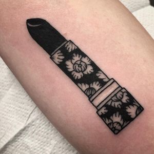 Exquisite fine line tattoo on arm by Claudia Trash featuring a beautiful flower and lipstick design.