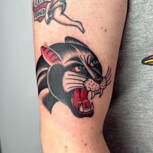 Get fierce vibes with this traditional panther tattoo by Claudia Trash, perfect for your upper arm. Stand out in style!