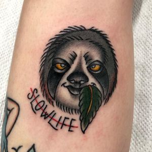 Unique sloth tattoo with meaningful quote, expertly done by Claudia Trash on the forearm. Embrace the slow pace of life.