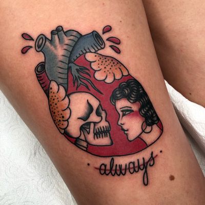 Get a traditional small lettering tattoo of a heart, skull, and woman on your upper leg with Claudia Trash's expert touch.