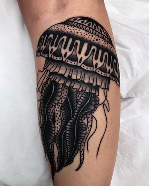 Unleash the power of the deep sea with this stunning lower leg tattoo by Claudia Trash. Intricate dotwork creates a mesmerizing blend of jellyfish and medusa motifs.
