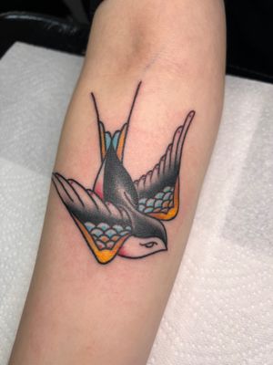 Get a timeless traditional bird tattoo on your forearm by the talented artist Claudia Trash. Stand out with this classic design!