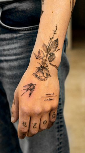 A stunning blackwork tattoo featuring a bird and flower motif, skillfully inked on the forearm in Berlin, DE.