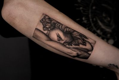 Get a stunning black and gray realism tattoo of an angel and lucifer battling it out on your forearm in Berlin, DE.