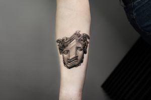 Eye-catching black and gray forearm tattoo of a mysterious Medusa intertwined with a snake, skillfully done in Berlin, DE.