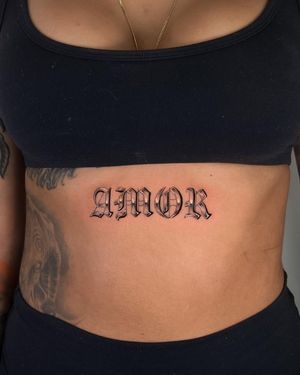 Embrace the power of love with this elegant lettering tattoo on your stomach. Created by the talented Joshua Williams.