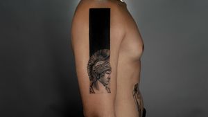 Get a stunning blackwork and realism tattoo of a knight statue on your upper arm in Berlin, Germany.