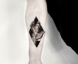 Blackwork forearm tattoo of a surreal statue in Berlin, DE. Combining realism with abstract elements.