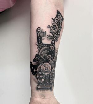 Experience the fusion of blackwork and surrealism with this stunning forearm tattoo featuring intricate gears and a futuristic robot design by VV Swain Tattoo.