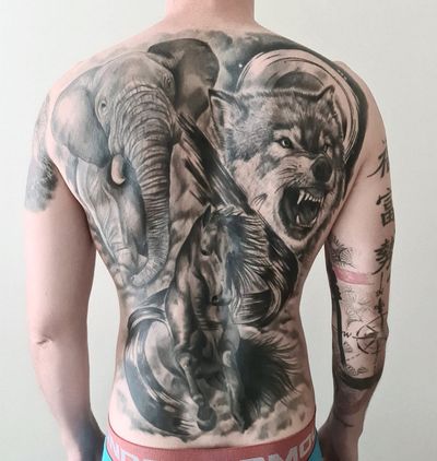Elegant black and gray realism tattoo featuring an elephant, horse, and wolf by VV Swain Tattoo.