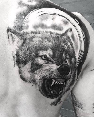 Impressive black and gray realism tattoo of a wolf by VV Swain Tattoo, beautifully placed on the upper back.